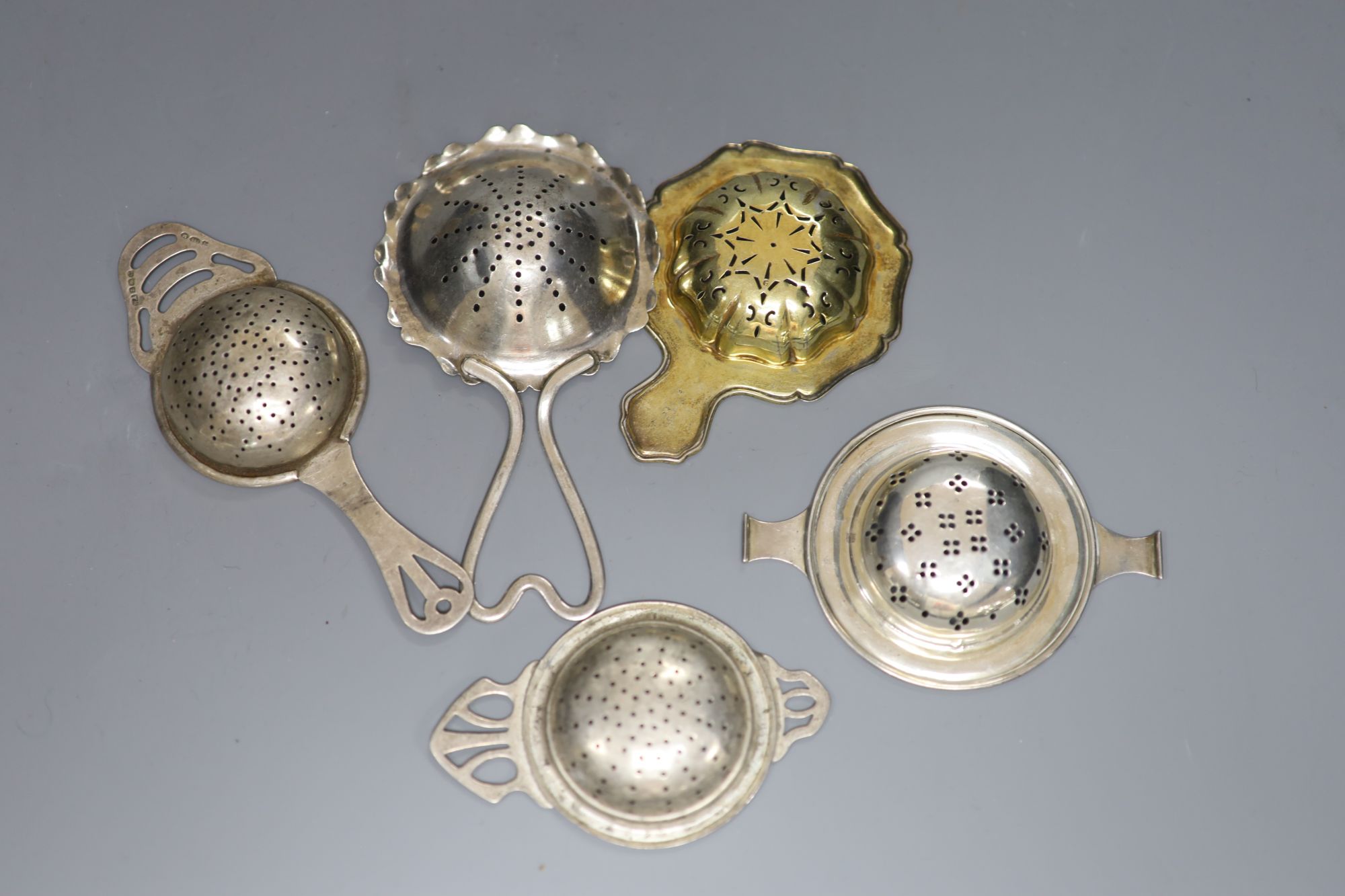 Five assorted 20th century silver tea strainers, 4oz.